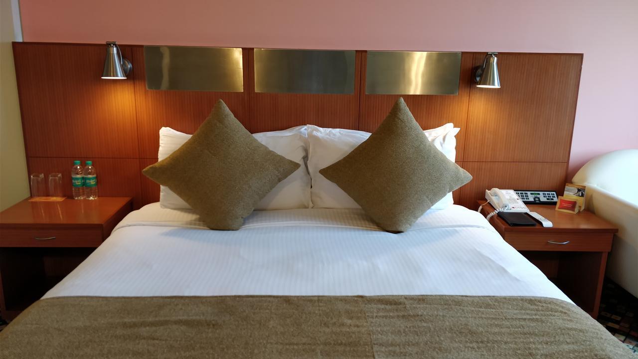 Hotel The Suryaa Nowe Delhi Zewnętrze zdjęcie A bed in a hotel room